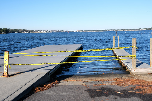 Caution tape meaning danger tapes off a boat ramp