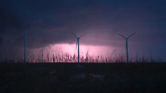 Extreme weather. Wind turbines under lightnings from a big storm.