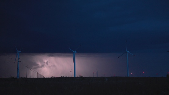 Extreme weather. Wind turbines under lightnings from a big storm.
