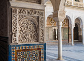 Arches and columns decorated incredible details of stucco yeseria decoration, with sebka motif, arabesques, and muqarnas sculpting - art of Moorish architecture in Casa de Pilatos, Seville, Spain.