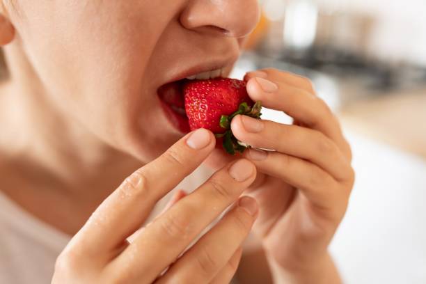 istock woman having breakfast with strawberries in her kitchen 1895927168