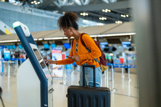 istock African woman using self Check-in kiosk machine at airport terminal. 1895940160