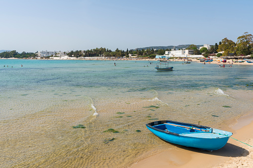 Traditional fishing boat on the sandy bech in Hammamet, Tunisia.