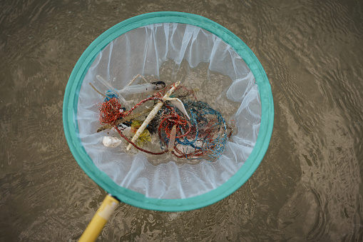 Plastic debris in the net above the ocean water.