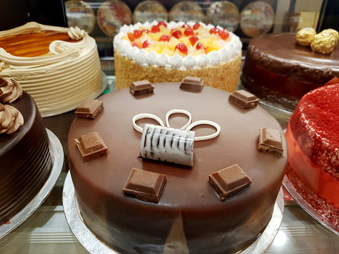 Variety of cakes in bakery rack.