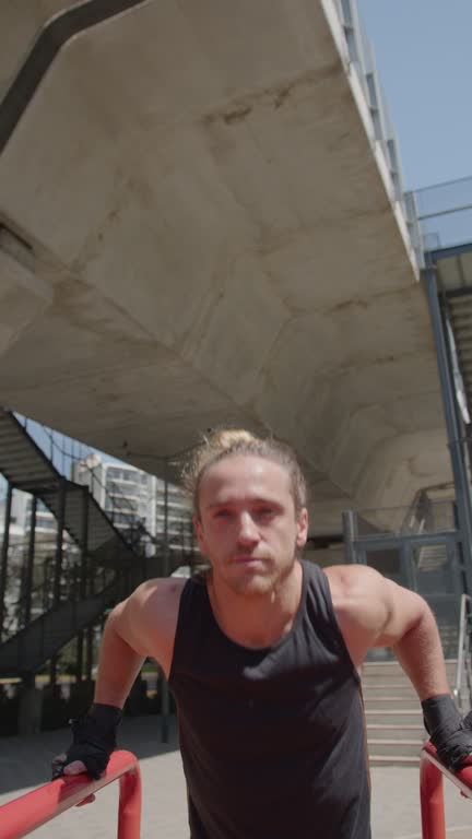 Man Doing Tricep Dips on Parallel Bars during Street Workout