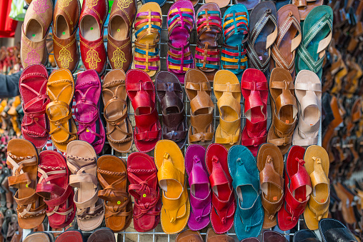 Colorful wall of sandals and slippers waiting for the tourists at the street shop in El Kantaoui