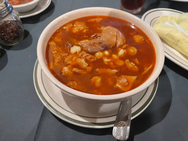 Large bowl of Menudo.   Trip, pigs feet, and soup in large white bowl.