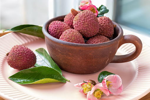 The bamboo basket under the lychee tree is full of ripe red lychees