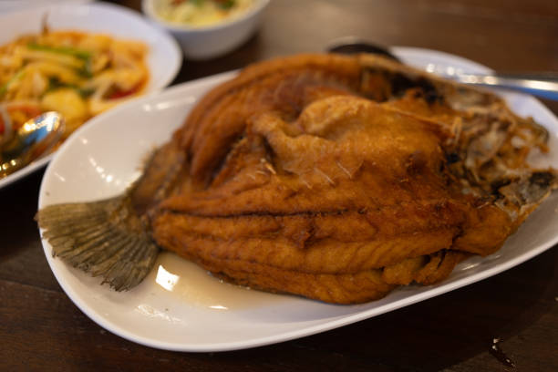 istock Deep fried fish, sea bass with fishsauce on the white plate 1896200568