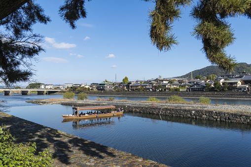 Uji, Kyoto, Japan - Nov 19 2023: Landscape of Uji River. Tourists having Daytime Sightseeing Cruises on the River