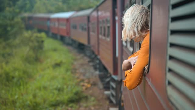 A woman enjoys a train ride in Sri Lanka