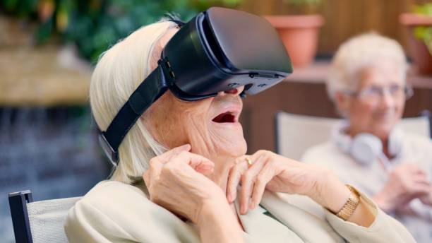 istock Shocked old woman using Virtual reality goggles in a geriatric 1896354793