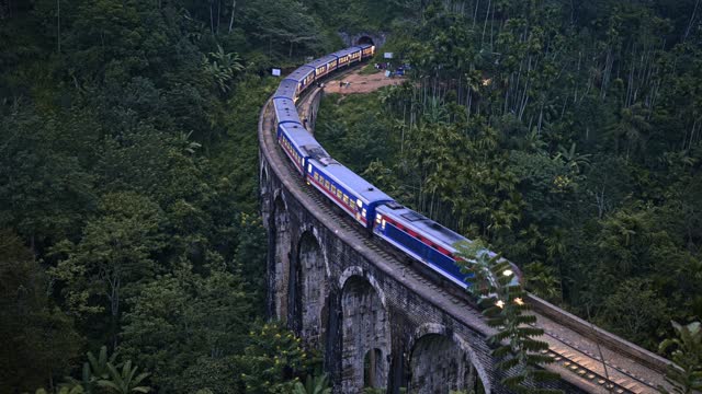 A panoramic view of a train passing over the Nine Arch Bridge in Ella, Sri Lanka