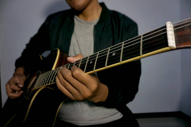 Close-up man playing acoustic guitar