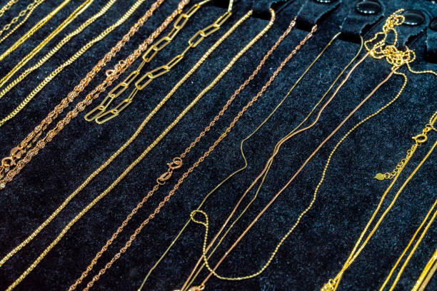 Close-up of a silver necklace with a teardrop-shaped clear gemstone, displayed on a black background