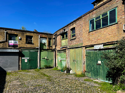 derelict houses and abandoned commercial property on a residential street with boarded up windows and decaying crumbling walls