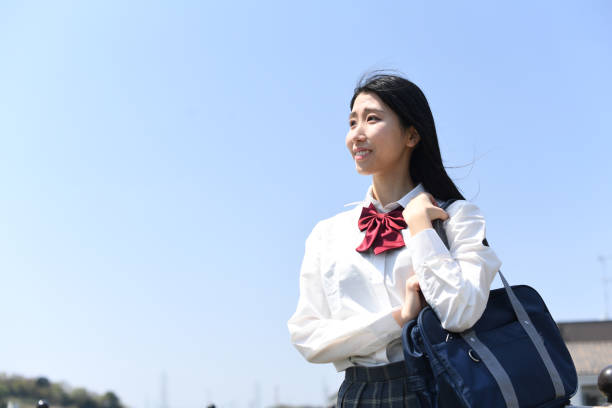 istock Asian female student standing outdoors under blue sky 1896543060