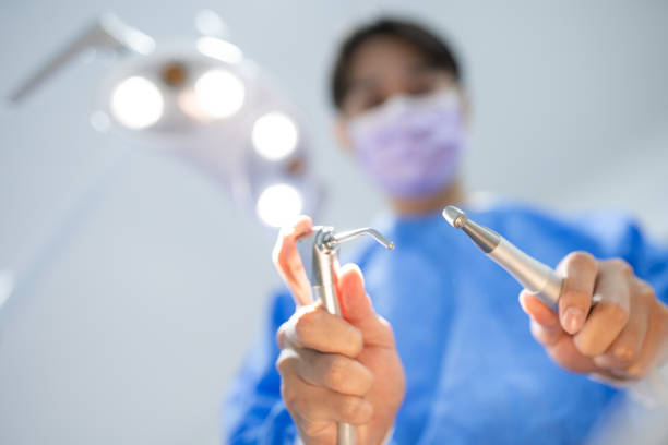 istock Male dentist in face mask and glasses doing treatment 1896599355