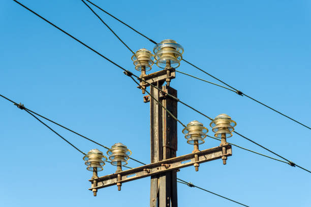 High voltage electricity pole against the blue sky.