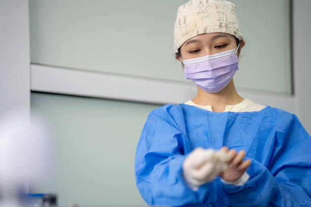 Female dentist in face mask and glasses doing treatment for patient blonde lady, holding dental tools, wearing rubber gloves. Stomatology, dentistry, modern dental clinic concept