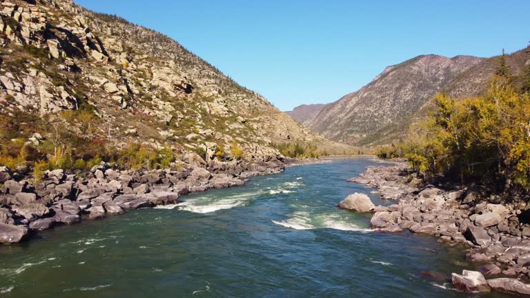 Rapid river flowing through rocky mountains during daytime