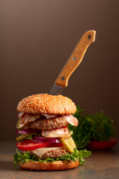 istock Fresh burger with knife on a brown background. 1896721374