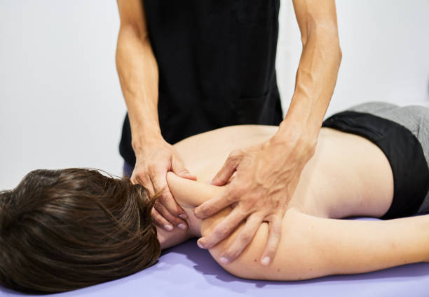 istock Massage therapist massaging female shoulders 1896721926