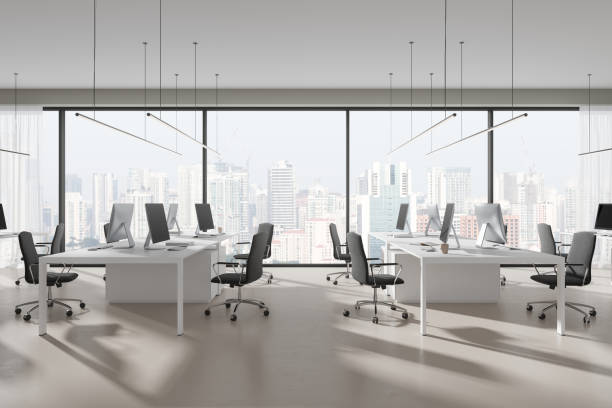 istock Stylish workspace interior with pc computers and table in row near window 1896770605