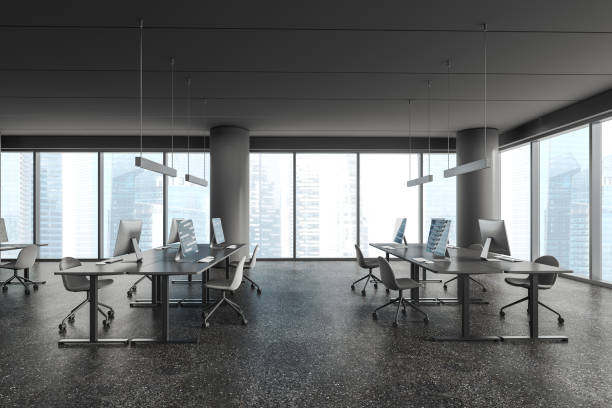 istock Grey office workplace interior with pc computers and table in row near window 1896813740