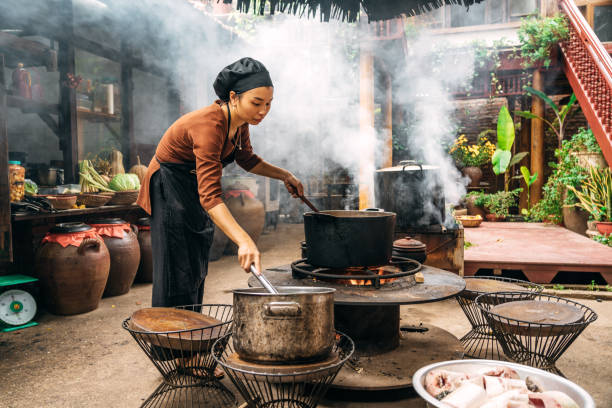 istock woman cooking steamed fish on open fire in restaurant 1896813786