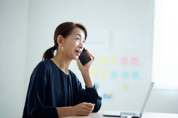 istock A senior Japanese woman makes a call using a smartphone in the office 1896836209