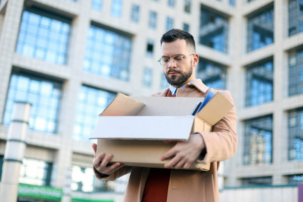 Fired man Mid adult man walking in a city street after being fired. About 30 years old, Caucasian male. being fired stock pictures, royalty-free photos & images