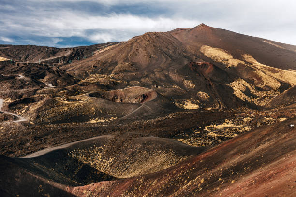 Etna volcanic landscape with a small human figure walking through.