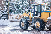 A large forklift is clearing snow