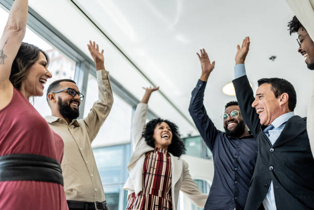 istock Coworkers celebrating with arms raised on the office 1896982703