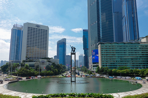 Jakarta, Indonesia – December 22, 2022: Selamat Datang Monument is a monument located in the middle of the Hotel Indonesia Roundabout, Jakarta, Indonesia. This monument is a statue of a pair of people holding flowers and waving their hands.