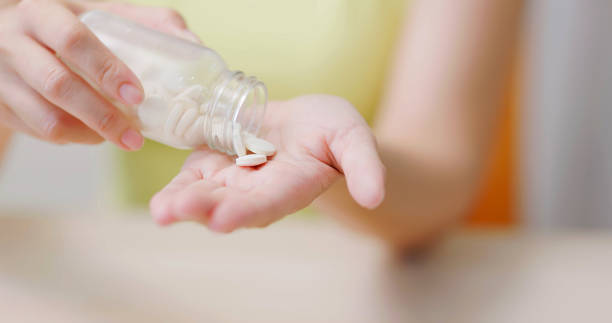 istock woman pour pills on hand 1897011247
