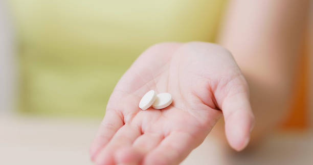 istock woman pour pills on hand 1897011771
