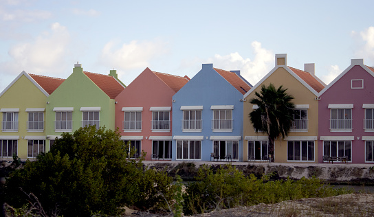 row if differently colored homes in tropical setting