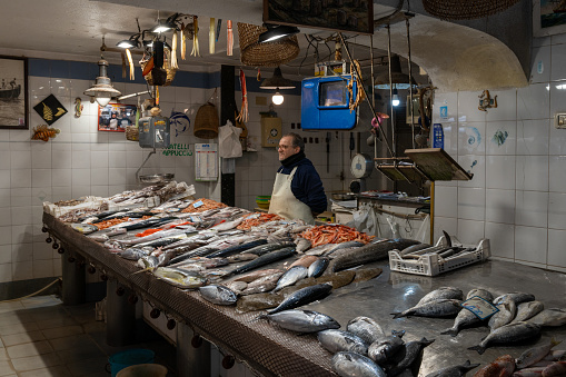 Syracuse, Italy - 28 December, 2023: fishmonger waiting for customers at the market in Isola di Ortigia in downtown Syracuse