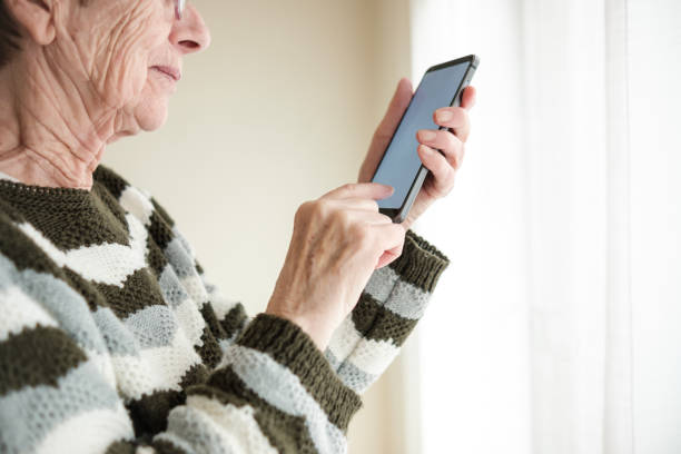 istock Side view of unrecognizable elder woman texting on her phone. 1897109814