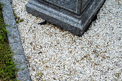 White gravel stone at the foot of a grave stone.