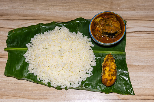 fresh and hot fish and rice cooked meal served at banana leaf for dinner