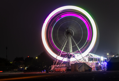 merry go round swing at night with colorful light at city fair ground and long exposure motion burr