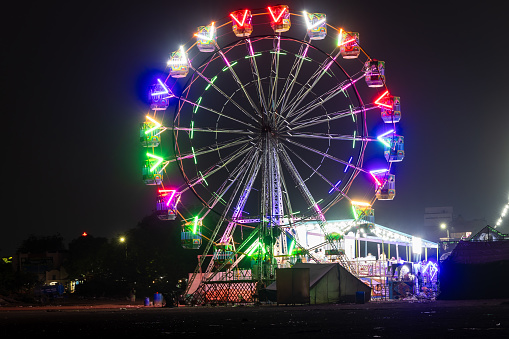 A carnival spins into the night with not a soul to be found.  Long exposure.