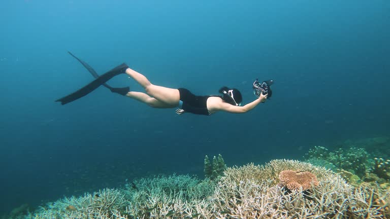 women freediving around beautiful coral reef garden undersea at coron palawan, philippine