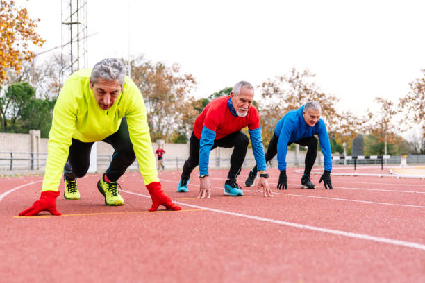 istock Ready to Race: Senior Runners Poised at the Start on Athletic Track 1897232027