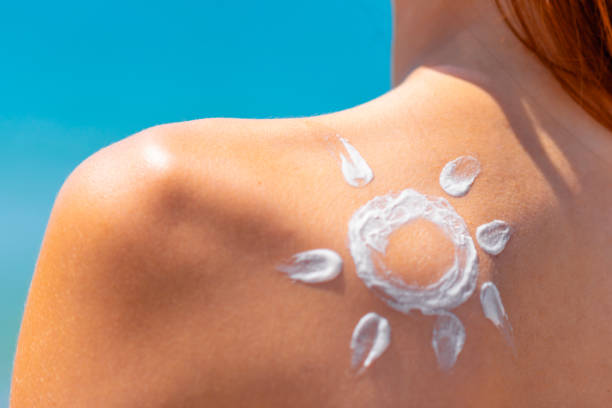 Sun made with cream at the shoulder Sunscreen lotion over tan woman skin, sun protection suntan lotion stock pictures, royalty-free photos & images