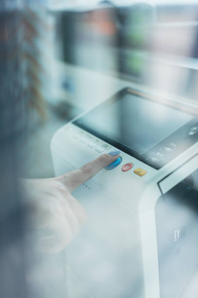 Step into the future of office technology with this dynamic stock photo, featuring a businesswoman's hand pressing the copy machine button in a modern office. The image captures the seamless blend of technology and business, symbolizing efficiency and progress. Ideal for conveying the futuristic aspects of office work, this photo is perfect for business-related promotions, technology publications, and social media content celebrating advancements in workplace automation, Touching the Future, Businesswoman, Copy machine, Modern office, Office Technology, Efficiency, Progress, Technology and business, Business-related promotions, Technology publications, Social media, Workplace automation advancements.